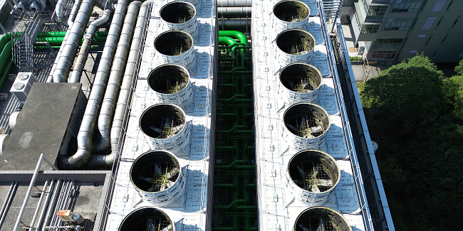 Top down aerial view of industrial cooling towers and pipelines for AI data center.